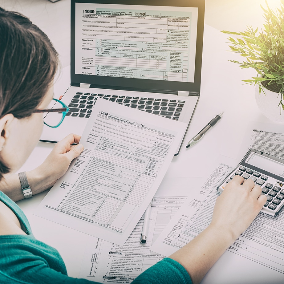 a woman is typing on a calculator while reading