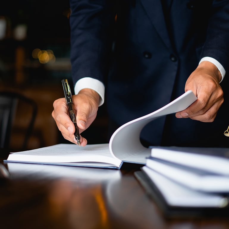 a man is using a pen and paper to write