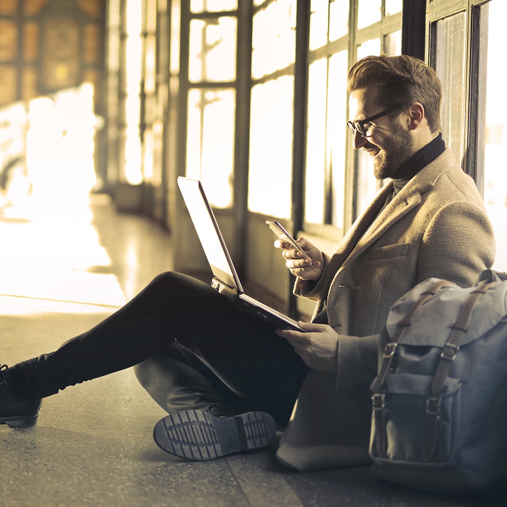 a man sitting on the floor looking at his phone