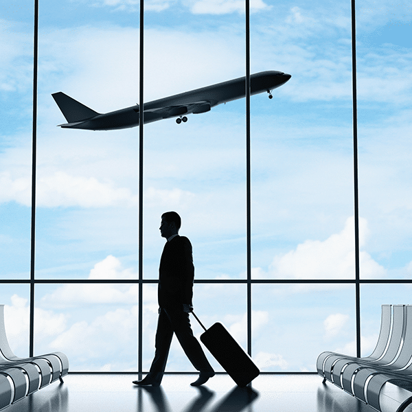 a man standing in front of a window with an airplane