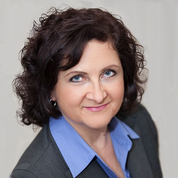 a woman in a suit and tie smiling