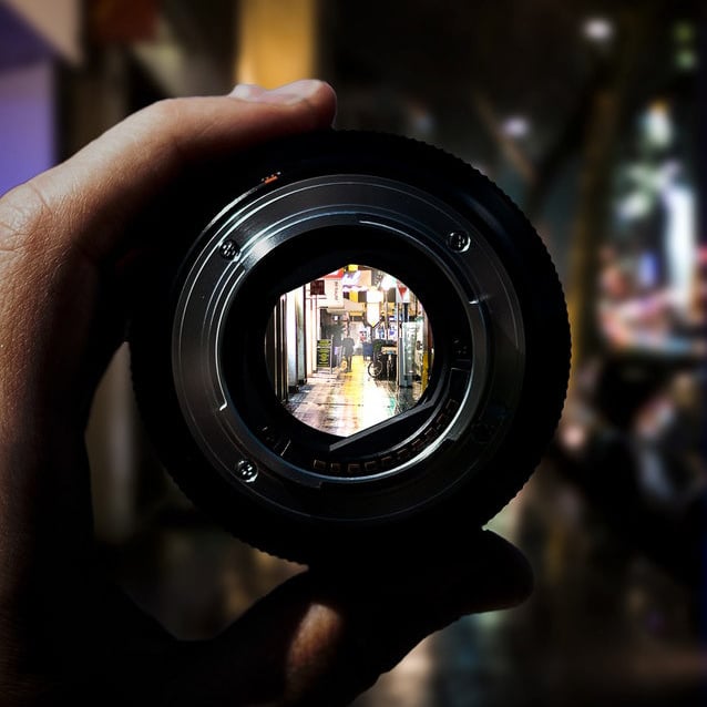 a person looking through a camera lense