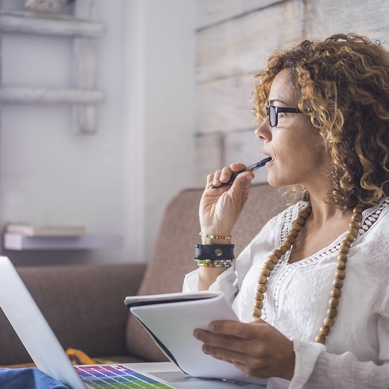 a woman is sitting in a chair and using a laptop