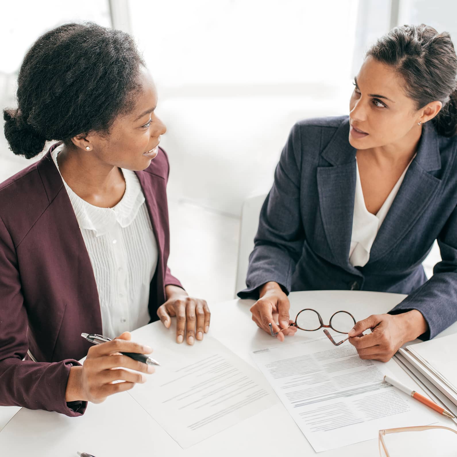 two women in suits talking to eachother