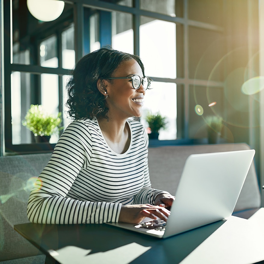 a woman sitting at a table using a laptop