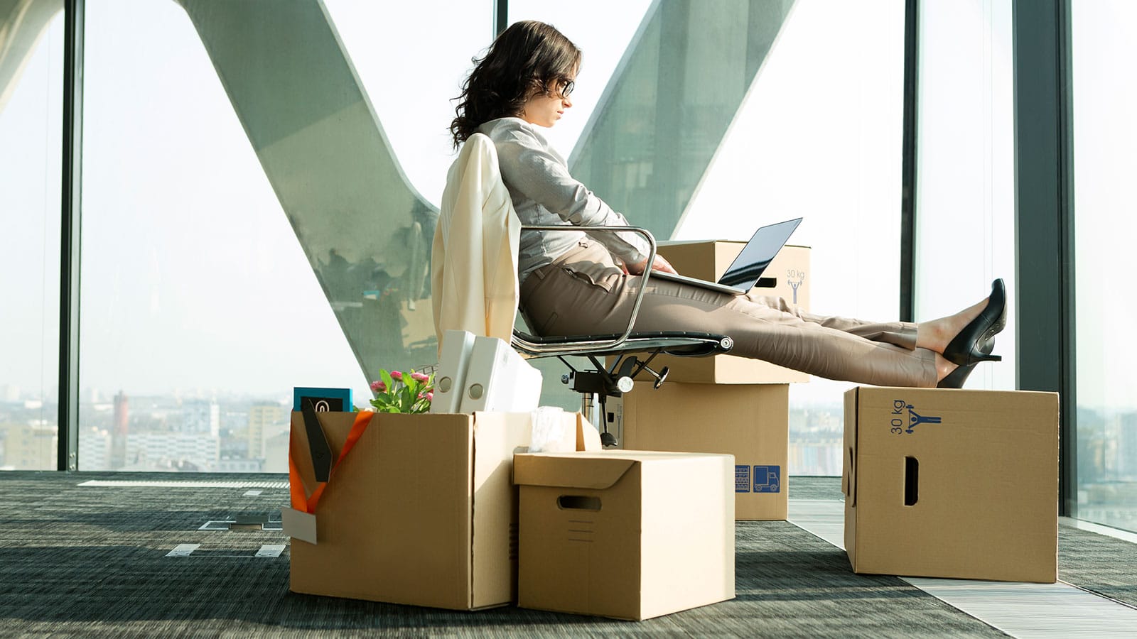 a woman sitting in a chair near boxes