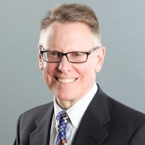 a man in a suit and tie smiling