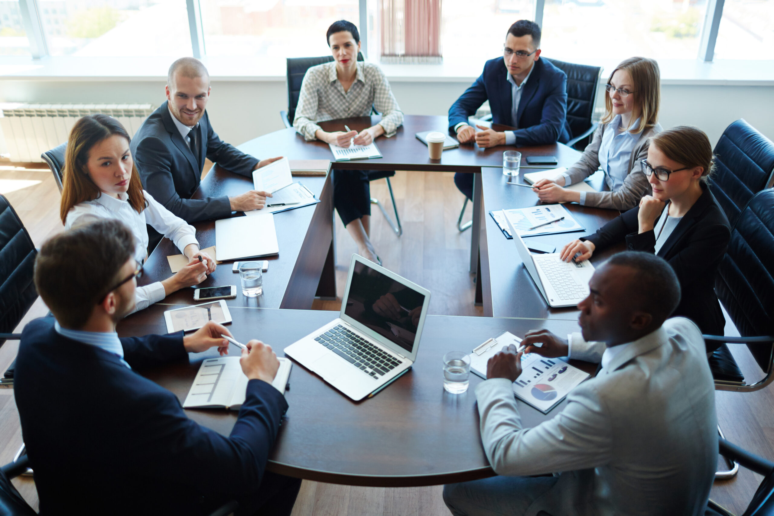 people sitting around a table with laptops